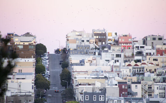 ピンク色の空に覆われたサンフランシスコの坂上の町並み